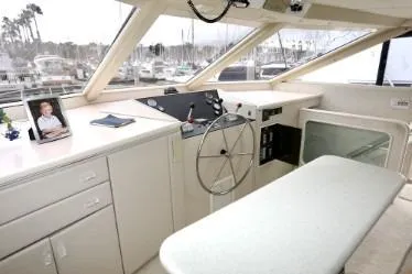 Scherzo Yacht Photos Pics Helm of a 1989 custom boat with steering wheel and marina view.