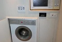 Scherzo Yacht Photos Pics Compact laundry area with a washing machine and microwave, custom design, 1989.