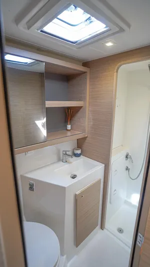 Good Times And Tan Lines Yacht Photos Pics 2023 Lagoon 42 yacht bathroom with modern fixtures and skylight.