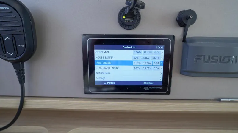 Good Times And Tan Lines Yacht Photos Pics Control panel display on 2023 Lagoon 42 catamaran showing battery and engine status.