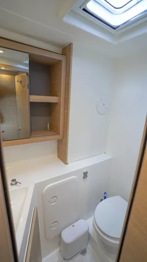 Good Times And Tan Lines Yacht Photos Pics Modern bathroom in 2023 Lagoon 42 yacht with skylight and wooden cabinetry.