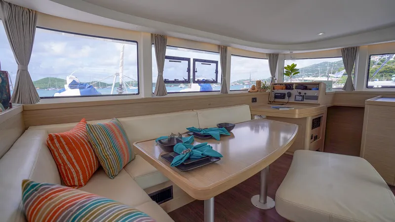 Good Times And Tan Lines Yacht Photos Pics Interior of 2023 Lagoon 42 yacht with elegant seating and vibrant cushions.