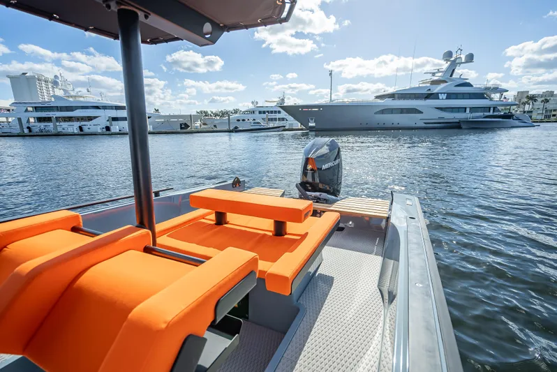  Yacht Photos Pics 2024 Goldfish 28 Tender boat with orange seats docked in a marina.