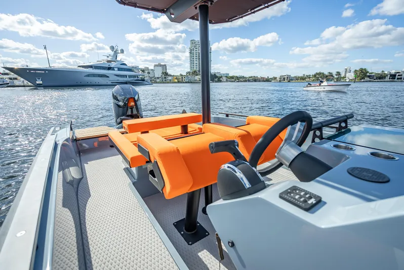  Yacht Photos Pics 2024 Goldfish 28 Tender boat with orange seating and modern controls on a sunny day.