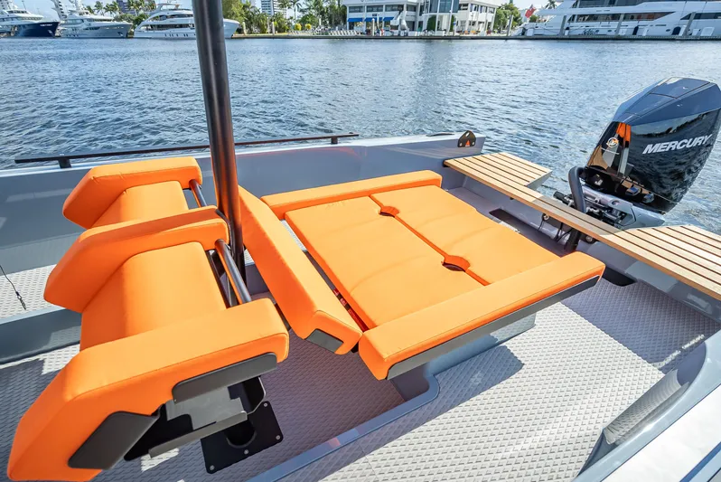  Yacht Photos Pics Goldfish 28 Tender 2024 with orange seating and Mercury outboard engine on water.