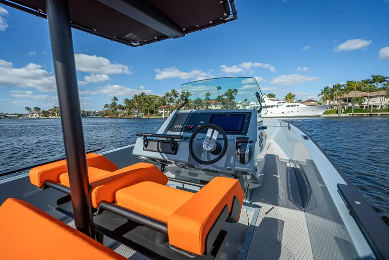  Yacht Photos Pics 2024 Goldfish 28 Tender boat with orange seats and modern dashboard on the water.