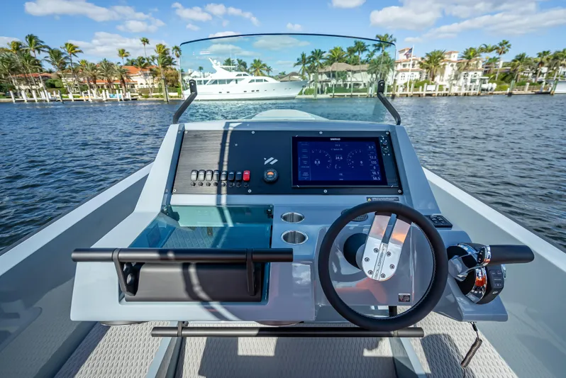  Yacht Photos Pics 2024 Goldfish 28 Tender boat dashboard with steering wheel and navigation system on a sunny day.