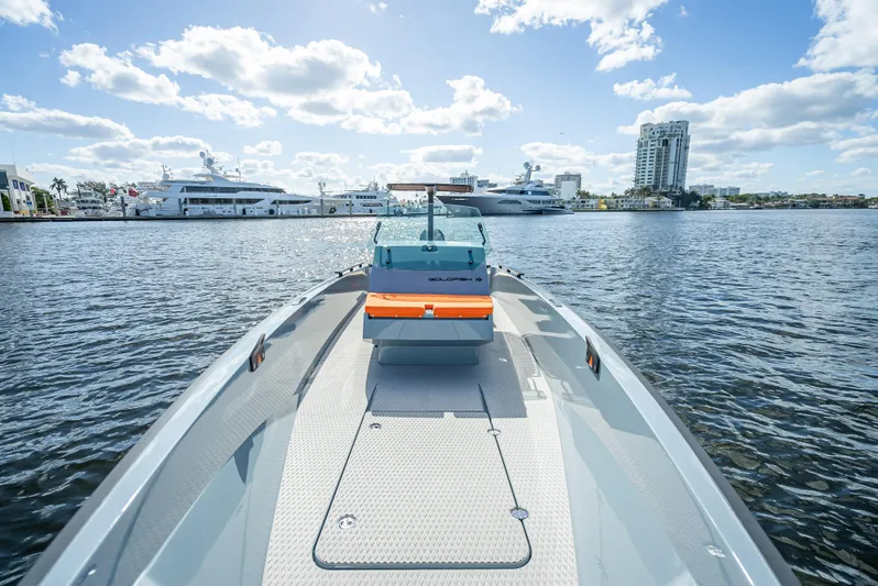  Yacht Photos Pics 2024 Goldfish 28 Tender boat on water with cityscape background.