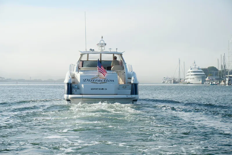 Distraction Yacht Photos Pics Sunseeker Camargue 50 yacht cruising in Newport Beach harbor, 2000 model, with American flag.