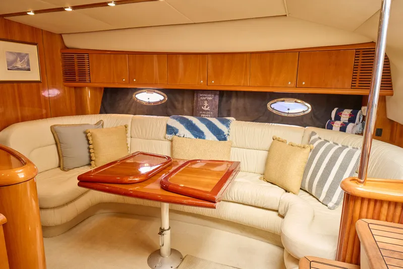 Distraction Yacht Photos Pics Luxurious interior of 2000 Sunseeker Camargue 50 yacht with plush seating and wooden accents.