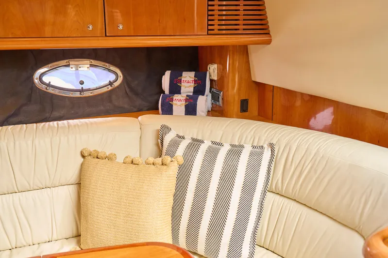 Distraction Yacht Photos Pics Luxurious interior of 2000 Sunseeker Camargue 50 yacht with plush seating and decorative pillows.