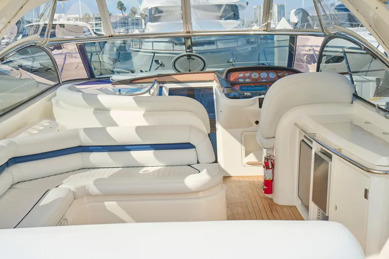 Distraction Yacht Photos Pics Luxurious interior of a 2000 Sunseeker Camargue 50 yacht with white seating and control panel.