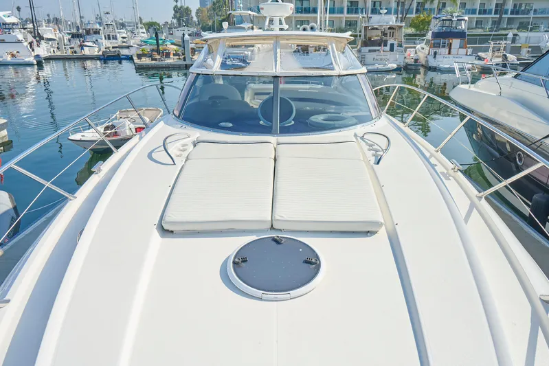 Distraction Yacht Photos Pics Sunseeker Camargue 50 yacht, 2000 model, docked in a marina with sunbathing area.