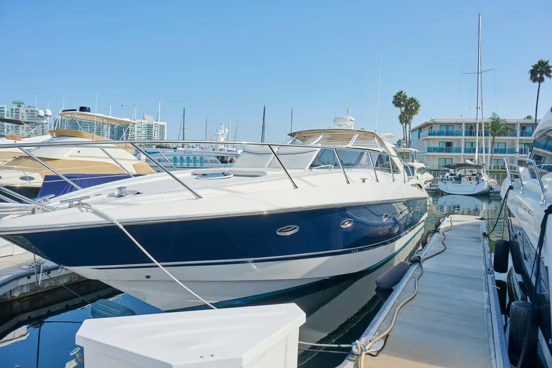 Distraction Yacht Photos Pics Sunseeker Camargue 50 yacht, 2000 model, docked at a marina under clear blue skies.