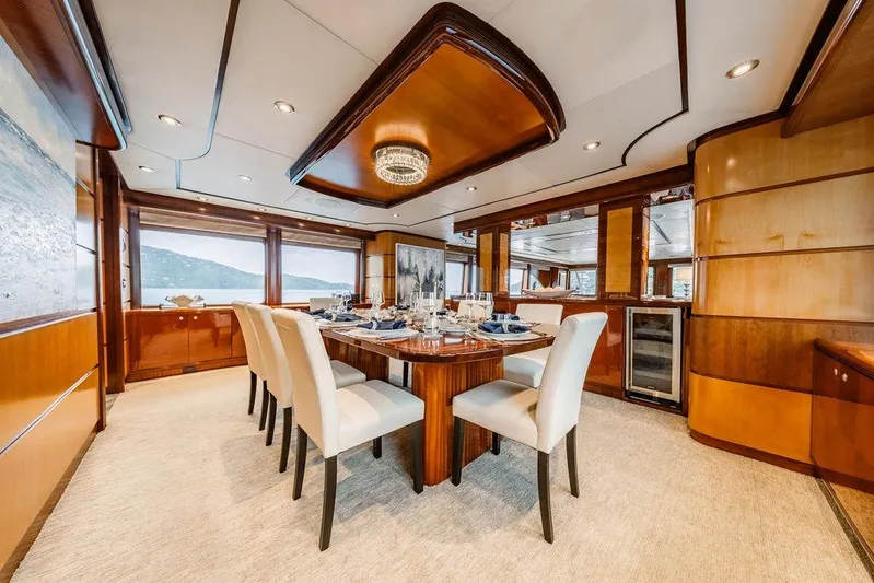Just Enough Yacht Photos Pics Luxurious dining area on 2012 Ares Custom Marine Custom 141 yacht, featuring elegant wood finishes.