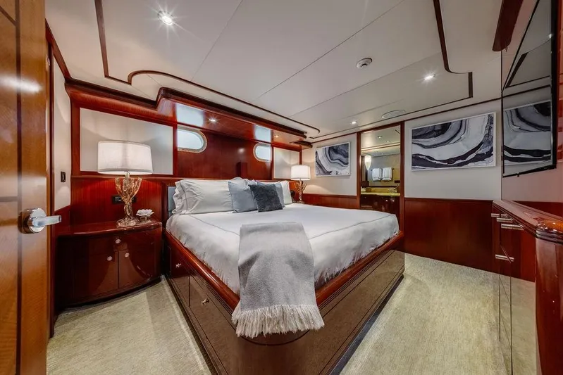 Just Enough Yacht Photos Pics Luxurious bedroom interior of 2012 Ares Custom Marine Custom 141 yacht, featuring elegant wood finishes.