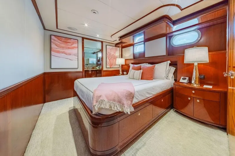 Just Enough Yacht Photos Pics Luxurious bedroom interior on 2012 Ares Custom Marine Custom 141 yacht, featuring elegant wood finishes.