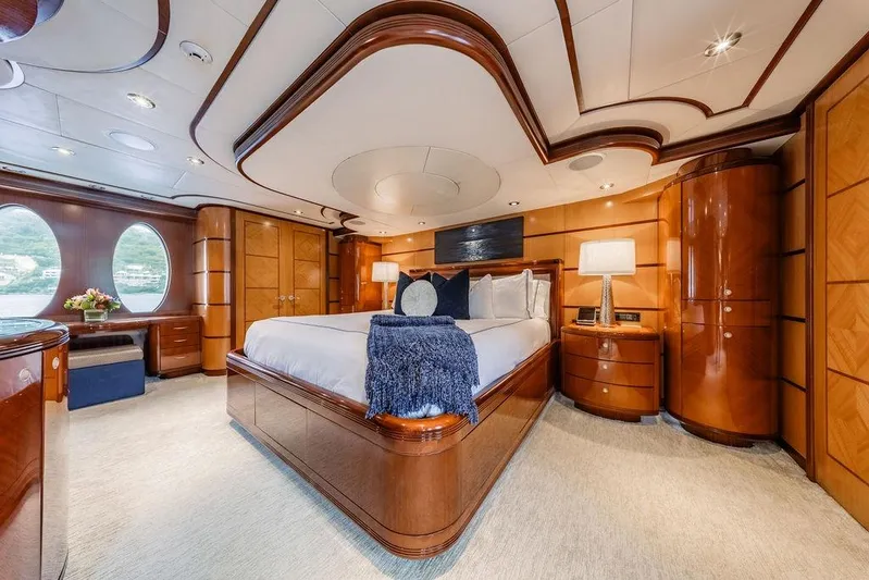Just Enough Yacht Photos Pics Luxurious bedroom interior on 2012 Ares Custom Marine Custom 141 yacht, featuring elegant wood finishes.