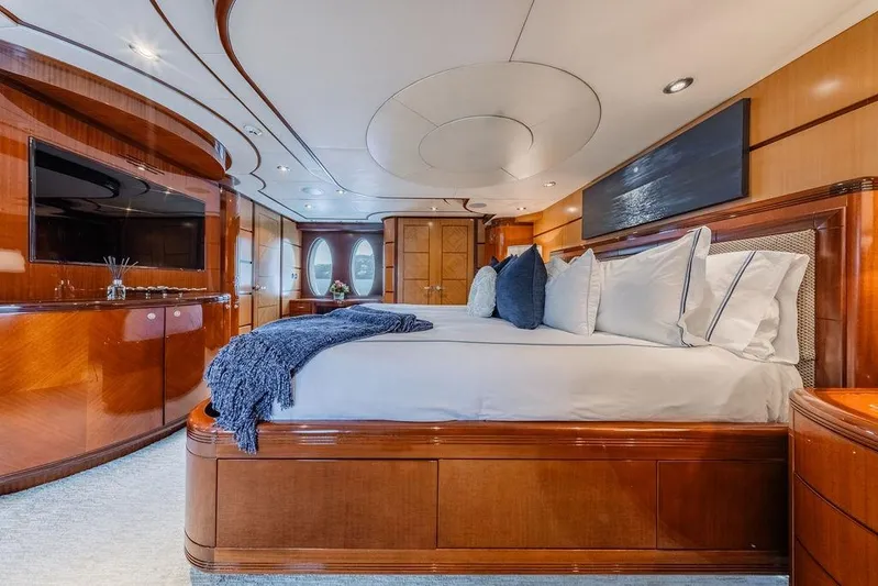 Just Enough Yacht Photos Pics Luxurious bedroom interior of 2012 Ares Custom Marine Custom 141 yacht, featuring elegant wood finishes.
