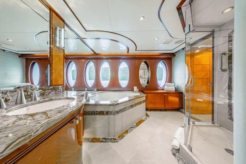 Just Enough Yacht Photos Pics Luxurious yacht bathroom with marble finishes, oval windows, and modern fixtures on Ares Custom Marine 141.