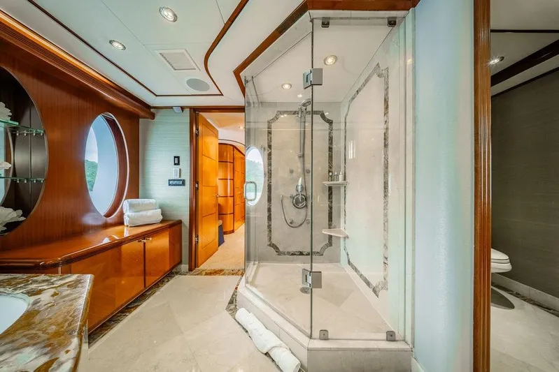 Just Enough Yacht Photos Pics Luxurious yacht bathroom with glass shower, wooden cabinetry, and porthole window, Ares Custom Marine 2012.