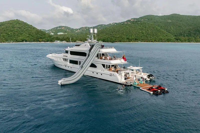 Just Enough Yacht Photos Pics Luxurious 2012 Ares Custom Marine yacht with slide, anchored near lush green hills.