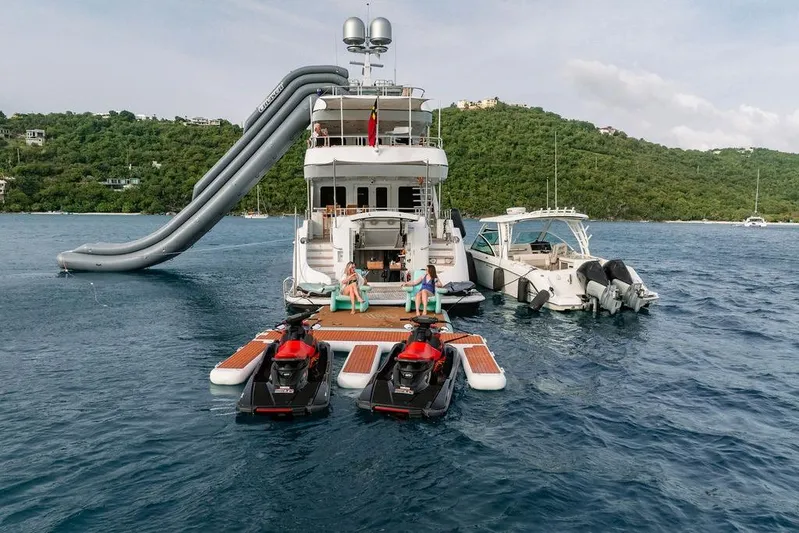 Just Enough Yacht Photos Pics Luxury yacht Ares Custom Marine 141 with slide, jet skis, and scenic ocean view.