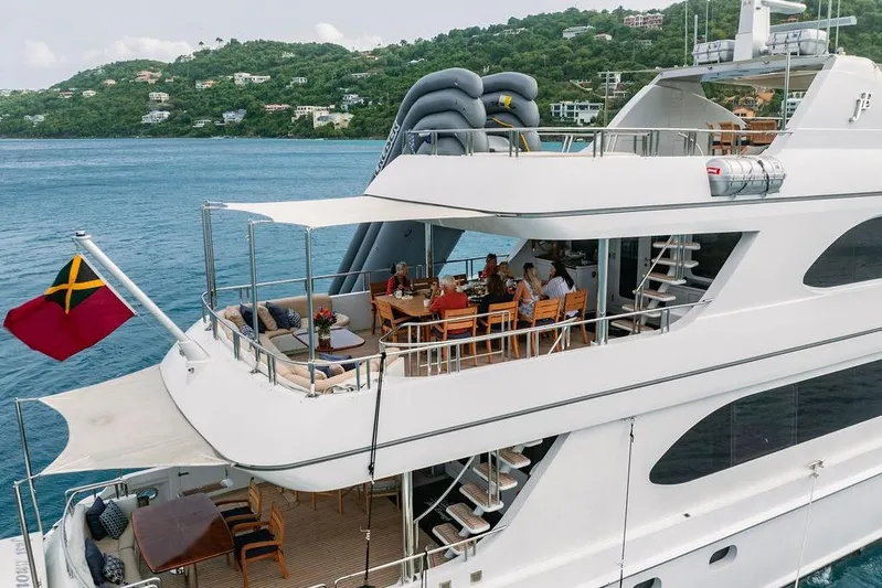 Just Enough Yacht Photos Pics Luxurious 2012 Ares Custom Marine yacht with guests dining on deck, scenic coastal backdrop.