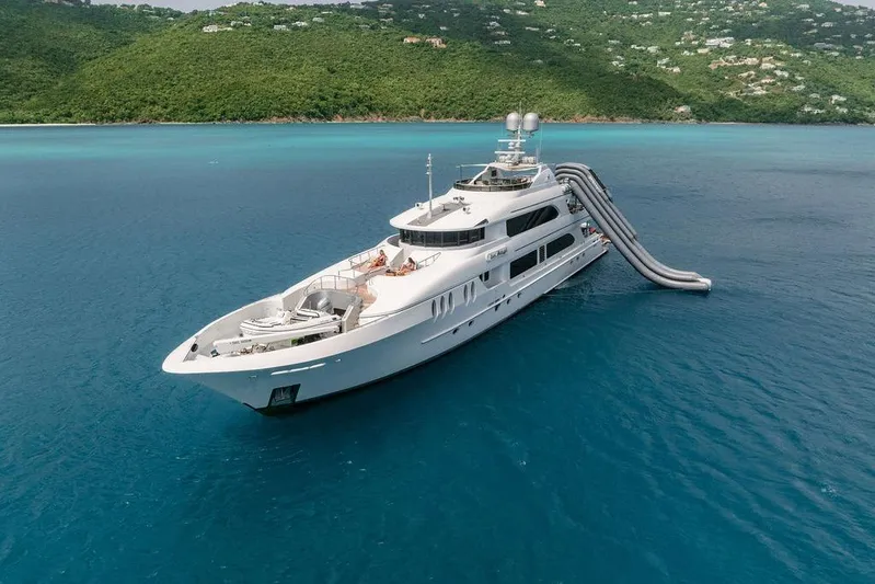 Just Enough Yacht Photos Pics Luxury yacht Ares Custom Marine 141, 2012, with water slide, anchored in turquoise sea.