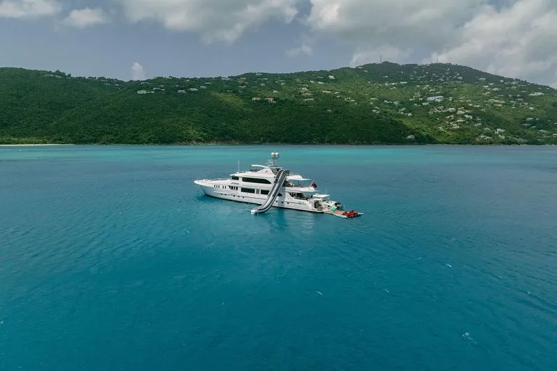 Just Enough Yacht Photos Pics Luxurious 2012 Ares Custom Marine yacht with slide, anchored in turquoise waters.