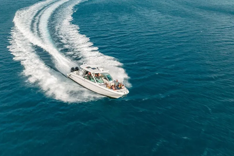 Just Enough Yacht Photos Pics Ares Custom Marine 2012 boat cruising on open blue water, creating a dynamic wake.