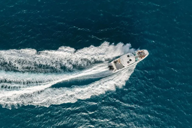 Just Enough Yacht Photos Pics Aerial view of 2012 Ares Custom Marine Custom 141 yacht cruising in blue ocean.