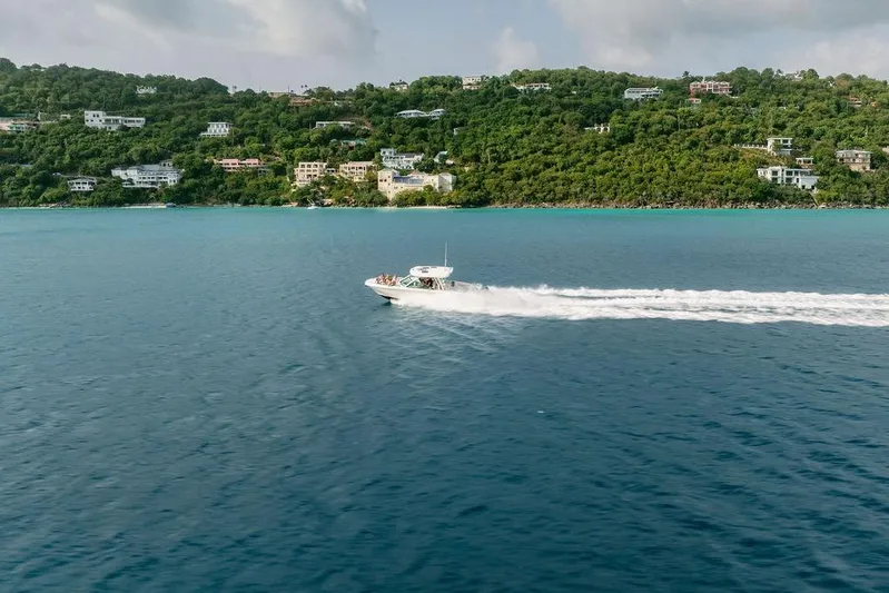 Just Enough Yacht Photos Pics Ares Custom Marine 2012 boat cruising near lush coastline, clear blue waters.