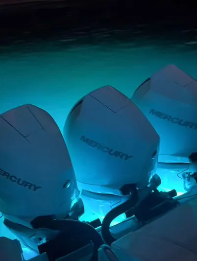 Mi Olvido Yacht Photos Pics 2023 Sea Ray Sundancer 320 Outboard with illuminated Mercury engines at night.