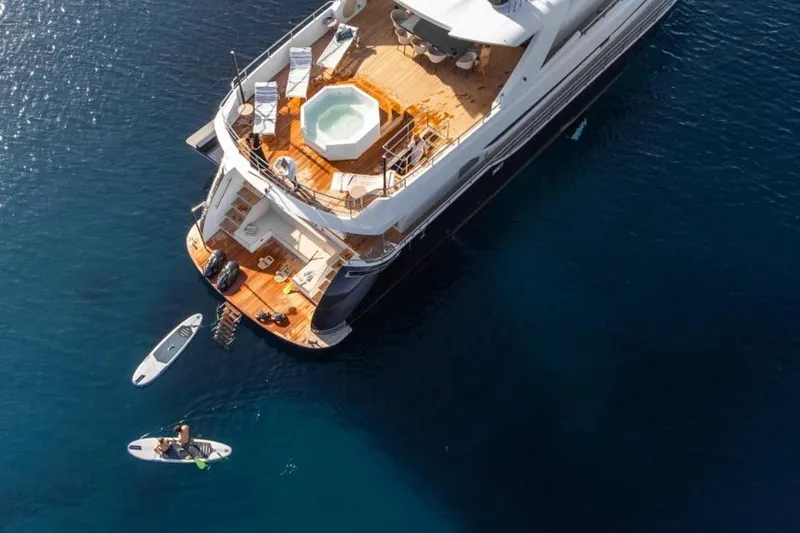 Eden Yacht Photos Pics Luxurious 2022 Maiora 30 Walkaround yacht with jacuzzi, paddleboards, and sun loungers on deck.