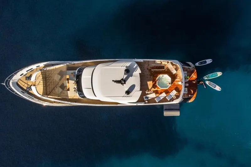 Eden Yacht Photos Pics Aerial view of 2022 Maiora 30 Walkaround yacht with paddleboards in blue water.
