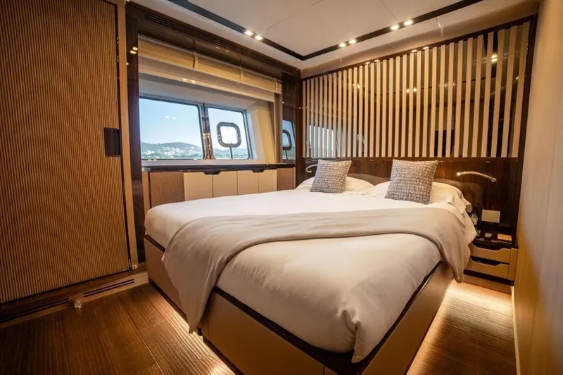 Eden Yacht Photos Pics Luxurious bedroom interior of 2022 Maiora 30 Walkaround yacht with elegant design and large window.