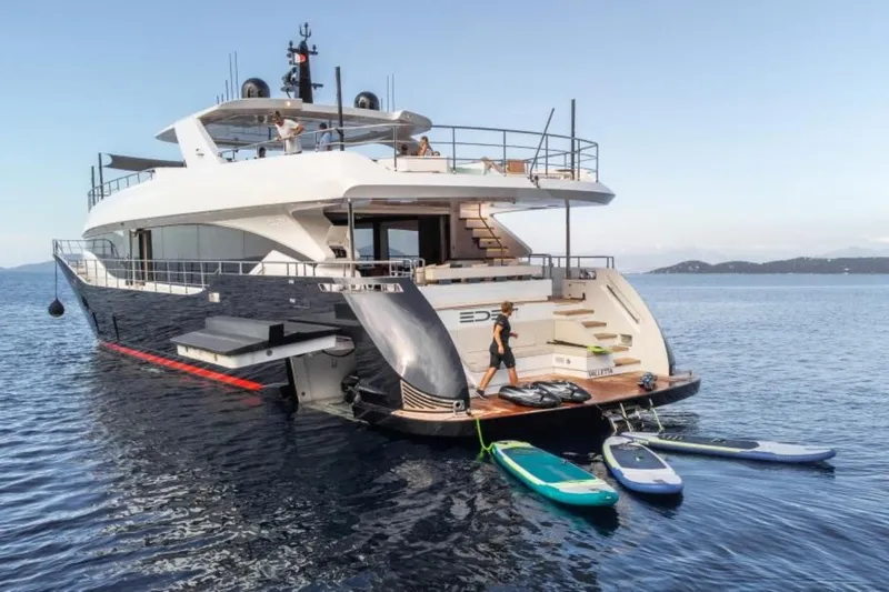 Eden Yacht Photos Pics Luxurious 2022 Maiora 30 Walkaround yacht with paddleboards on calm sea.