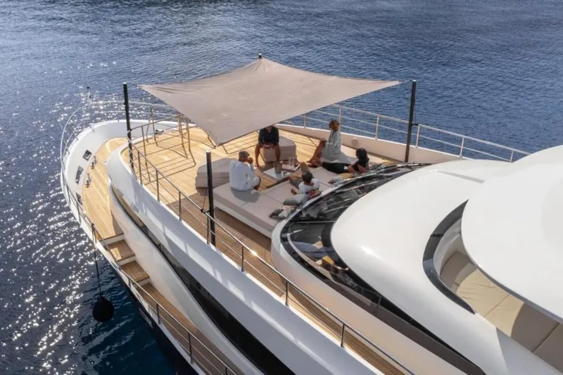 Eden Yacht Photos Pics Luxurious 2022 Maiora 30 Walkaround yacht with people relaxing on deck under a canopy.