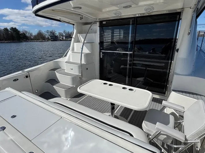  Yacht Photos Pics 2005 Sea Ray 500 Sedan Bridge yacht deck with seating and table, overlooking serene water.