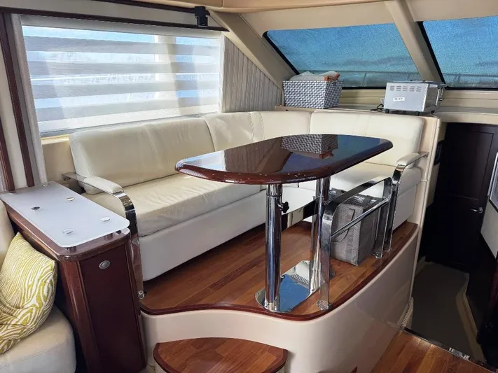  Yacht Photos Pics Luxurious interior of 2005 Sea Ray 500 Sedan Bridge with elegant seating and wooden table.