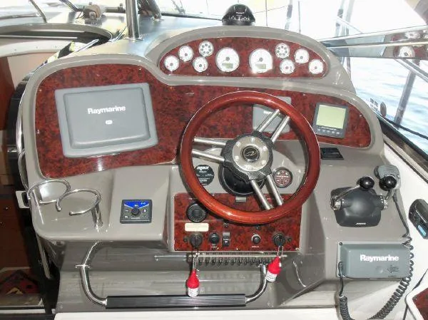  Yacht Photos Pics 2009 Regal Commodore 4060 helm with Raymarine electronics and wood-trimmed steering wheel.