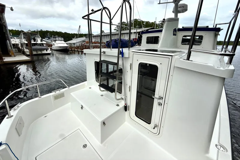 Blue Wander Yacht Photos Pics 2023 Nordic Tug 34 docked, showcasing rear deck and cabin entrance.