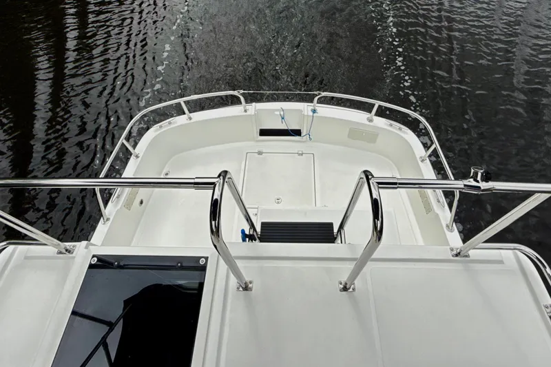 Blue Wander Yacht Photos Pics 2023 Nordic Tug 34 Tug boat deck with railing, overlooking water.