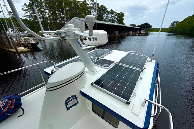 Blue Wander Yacht Photos Pics 2023 Nordic Tug 34 with solar panels on deck, docked by a serene marina.