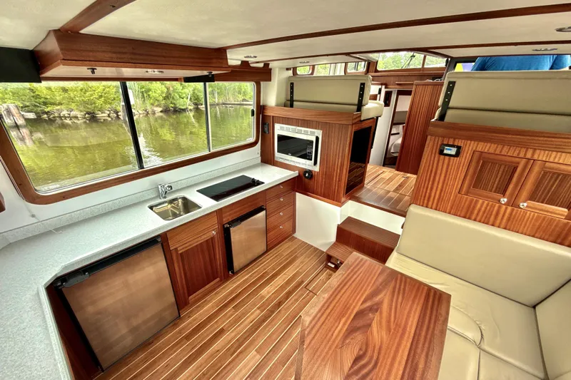 Blue Wander Yacht Photos Pics Interior of 2023 Nordic Tug 34, featuring modern kitchen and seating area with wood finishes.