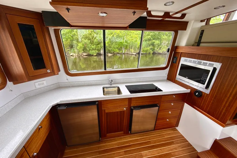 Blue Wander Yacht Photos Pics 2023 Nordic Tug 34 interior kitchen with modern appliances and scenic window view.
