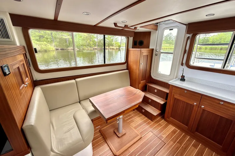Blue Wander Yacht Photos Pics Interior of 2023 Nordic Tug 34, featuring wood finish, seating, and large windows.