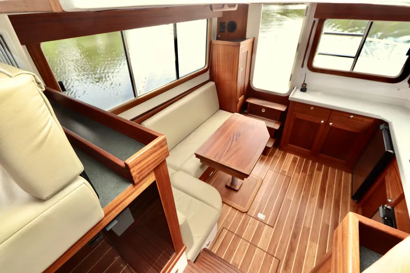Blue Wander Yacht Photos Pics Interior of 2023 Nordic Tug 34, featuring wood finishes and comfortable seating.