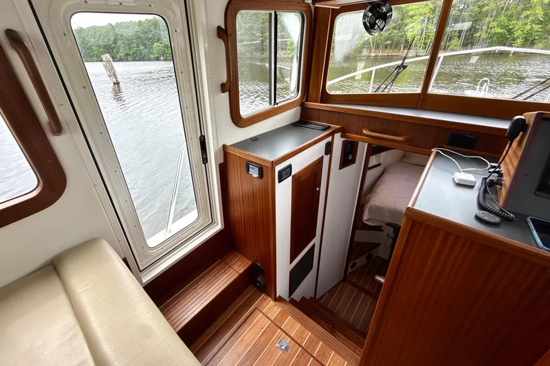 Blue Wander Yacht Photos Pics Interior of 2023 Nordic Tug 34, featuring wood paneling and water view.